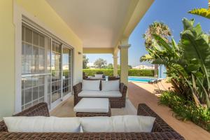 阿尔沃尔Villa Amarela的一个带柳条家具的户外庭院和游泳池