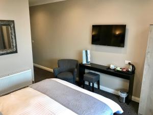 科比渡鸦酒店的酒店客房配有一张床、一张书桌和一台电视。