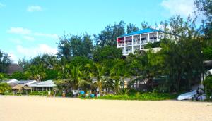 托弗海滩Casa Do Mar Guest House的海滩边的一座树木繁茂的建筑