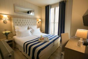 巴黎亚历山大歌剧院酒店的酒店客房,配有一张带蓝白条纹毯子的床