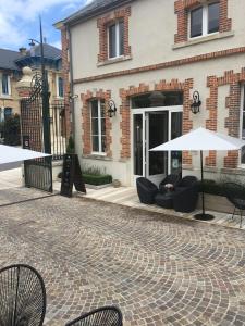 埃佩尔奈香槟白吉尔安德烈住宿加早餐旅馆的大楼前带椅子和遮阳伞的天井