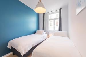 布鲁塞尔Smartflats - Toison d'Or的配有两张床铺的蓝色墙壁和窗户