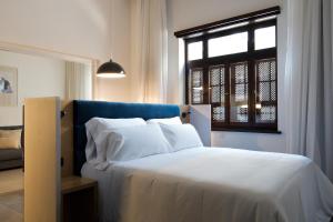 大加那利岛拉斯帕尔马斯Suites 1478的一间卧室配有一张带白色床单的床和一扇窗户。
