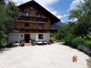 巴特奥塞Haus Galler - Urlaub am Bauernhof的坐在房子前面的狗