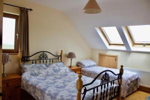 瓦伦西亚岛Cuas a' Gamhna的卧室设有两张床和天窗。