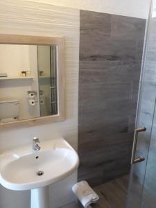 圣詹姆斯热带日落海滩公寓式酒店的浴室配有盥洗盆和带镜子的淋浴