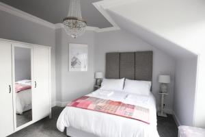 博特夫加滕High Terrace Apartment的卧室配有白色的床和吊灯。