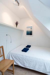 弗雷登斯堡Pedersminde Guesthouse的白色卧室配有床和木椅