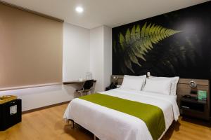 麦德林维乌尔酒店的一间卧室配有一张带绿毯的大床