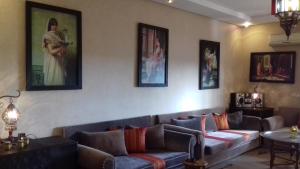 达布阿扎Perle de Tamaris的客厅配有沙发和墙上的绘画