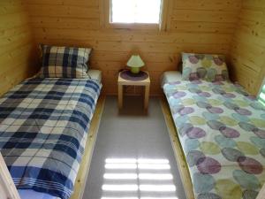 米兹多洛杰Lesny domek的小木屋内的两张床和桌子