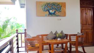 乌布拉马尼亚旅馆的一间带桌椅和绘画的用餐室