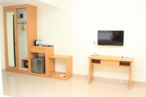 古邦库庞纳卡酒店的配有电视和带镜子的桌子的房间
