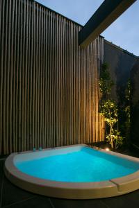 宫崎The Meibia Miyazaki的木墙前的游泳池