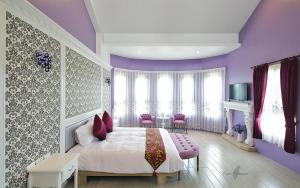 五结爱町堡私人会馆的紫色卧室配有一张床和一张桌子及椅子