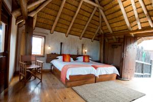 斯瓦科普蒙德Stiltz Guest House的铺有木地板的客房设有一间带大床的卧室