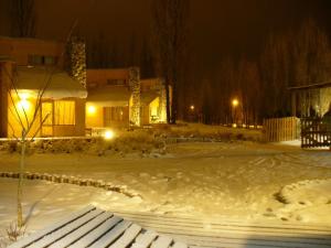 马拉圭柯隆山林小屋的雪覆盖的院子,晚上有房子