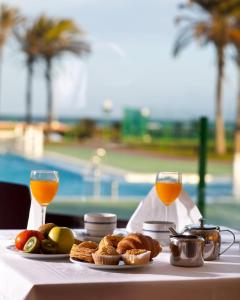 滨海罗克塔斯埃文尼亚索莱达花园酒店的一张桌子,上面放着食物和两杯橙汁
