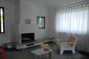 CastelnuovoB&B La Montagna Rosa的客厅设有壁炉和椅子