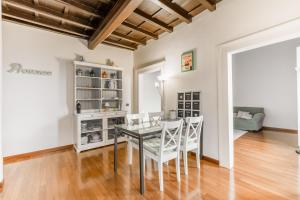 罗马Navona Bernini Lodge的一间设有玻璃桌和白色椅子的用餐室