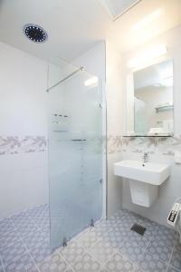 西归浦市加利福尼亚酒店的一间带玻璃淋浴和水槽的浴室