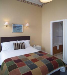 弗利特伍德北尤斯顿酒店的一间卧室配有一张带彩色毯子的床