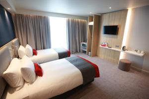 曼彻斯特曼彻斯特特拉福德城智选假日酒店的酒店客房设有两张床和电视。
