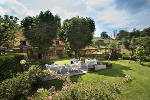 Paesana拉克莱塔酒店的花园的图象,花园中摆放着白色的桌椅