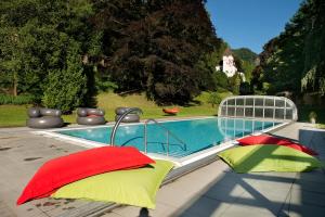 拉格斯拉加茨城堡酒店的游泳池旁设有红色和绿色枕头
