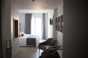 卡沃内拉斯El Trebol Bar & Hotel Only Adults的配有一张床和一把椅子的酒店客房