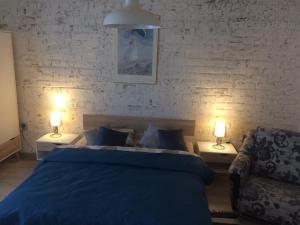Biksti多兹纳维那斯汽车旅馆的一间卧室配有一张蓝色的床和两盏灯。