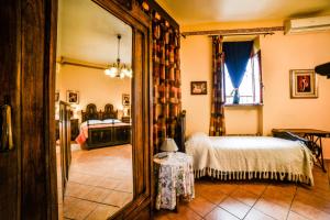 MazzèB&B La Casa Gialla Di Luca的一间卧室配有一张床和一面大镜子