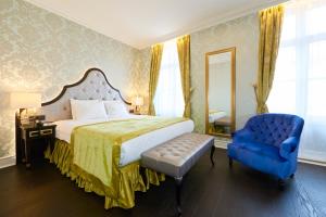 布鲁塞尔斯坦霍普酒店 - 索恩酒店旗下的一间卧室配有一张床和一张蓝色椅子