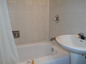 温尼伯圣诺伯特酒店的浴室配有白色浴缸和水槽