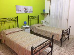托雷拉皮罗Casa Alieta的绿墙客房内的两张床