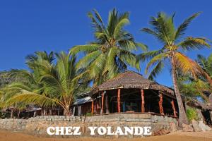 AmpangorinanaChez Yolande的棕榈树海滩上的一座建筑