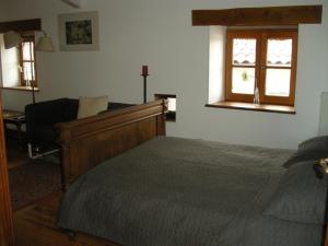 GrazacAuberge BRIASSOU的卧室配有床、椅子和窗户。