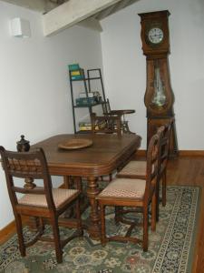 GrazacAuberge BRIASSOU的一间带木桌和祖父钟的用餐室