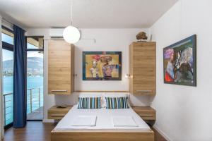蒂瓦特Villa Tajna的卧室配有一张床,墙上挂有绘画作品