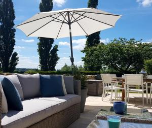 利托埃卢维尔庄园旅馆的庭院里设有白色的沙发和遮阳伞。