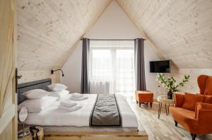 扎科帕内Tatra Wood House的一间卧室配有一张大床和一把椅子