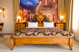 巴库巴库精品酒店的卧室配有一张大床,墙上挂有绘画作品