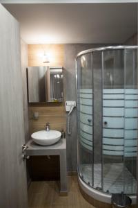 阿莫利亚尼岛Pallas Luxury Apartments的一间带水槽和玻璃淋浴的浴室