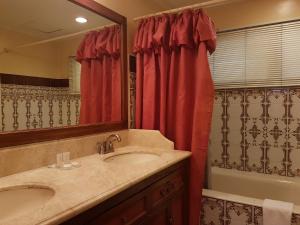 宿务索菲亚套房公寓式酒店的一间带水槽、浴缸和镜子的浴室