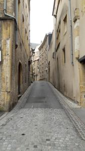 梅斯Chic En Ville的两座建筑之间的小巷里一条空的街道