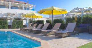 蒙蒂戈杜洛萨琳达酒店的一组椅子和遮阳伞,位于游泳池旁