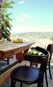 培拉特Guest House Vasili的一张带椅子的木桌和一张带水果的桌子