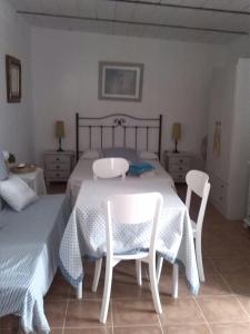 奇克拉纳－德拉弗龙特拉La posada的一间卧室配有一张带两把椅子和一张桌子的床。