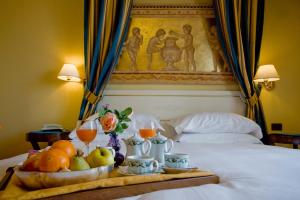 萨尔索马焦雷泰尔梅Hotel Ferrari的床上的水果和饮料托盘