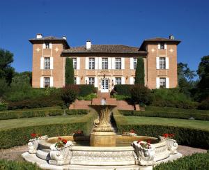 Lombez巴贝特城堡居所酒店的一座大房子前面有一个喷泉